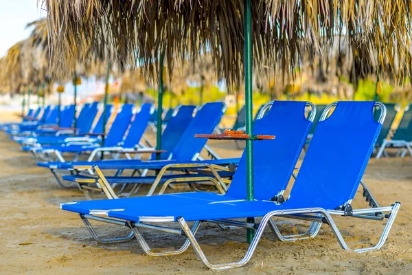 Camas de praia com guarda-sóis de palha — Fotografia de Stock