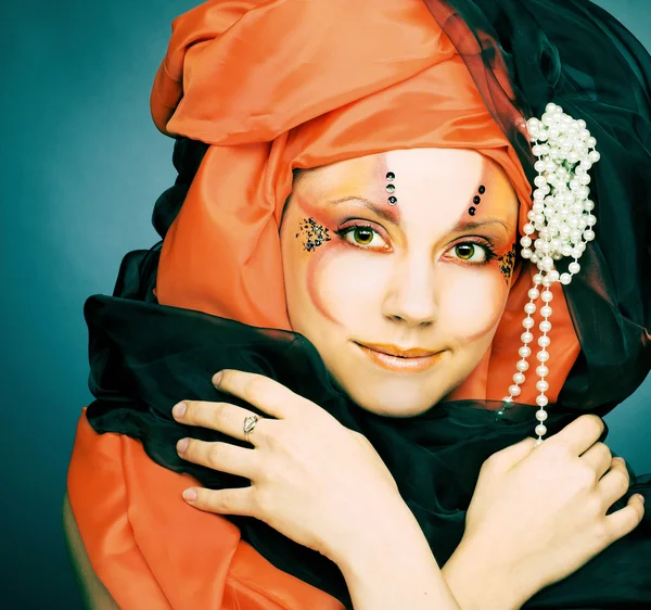 Jonge vrouw in zwart en oranje tulband — Stockfoto