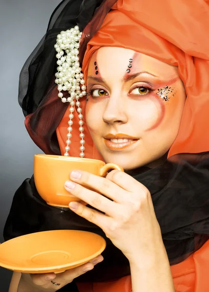 Mladá žena v černé a oranžové turban — Stock fotografie