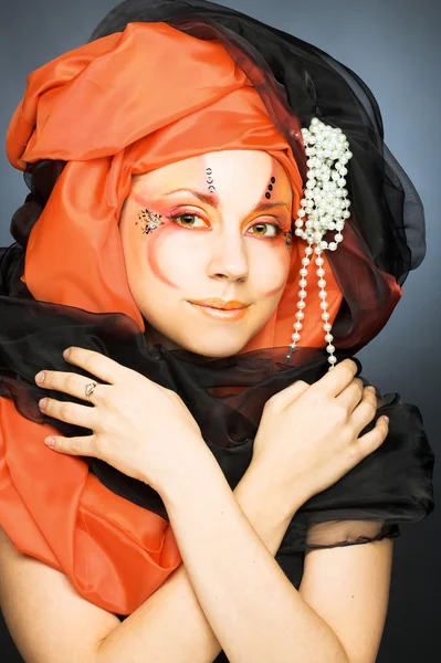 Ung kvinna i svart och orange turban — Stockfoto