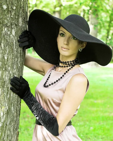 Jonge vrouw in zwarte hoed — Stockfoto
