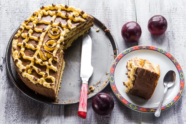 Trancher la sueur gâteau crème tableau en bois prunes prunes blanches — Photo