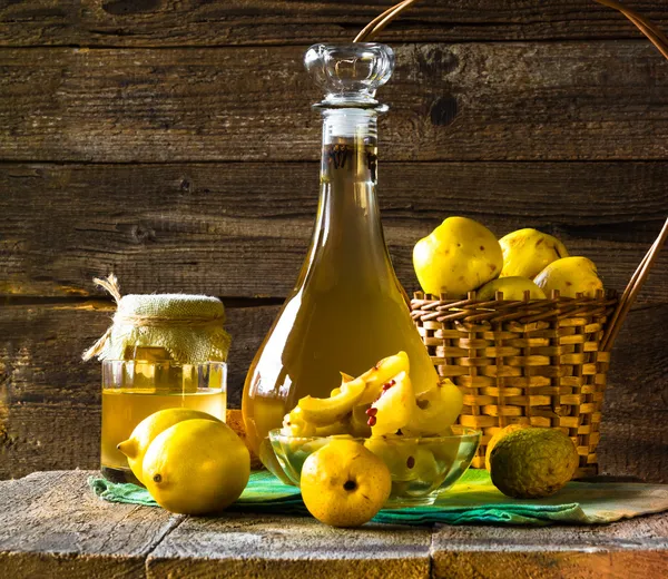 Alcohol membrillo licor en rodajas de frutas preparar entorno de madera —  Fotos de Stock