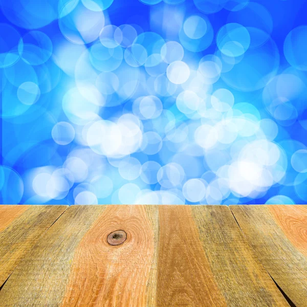 Blauwe bokeh achtergrond houten tafel — Stockfoto