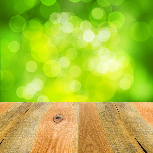 Green bokeh background wooden table — Stock Photo, Image