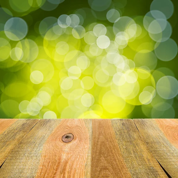 Green bokeh background wooden table — Stock Photo, Image