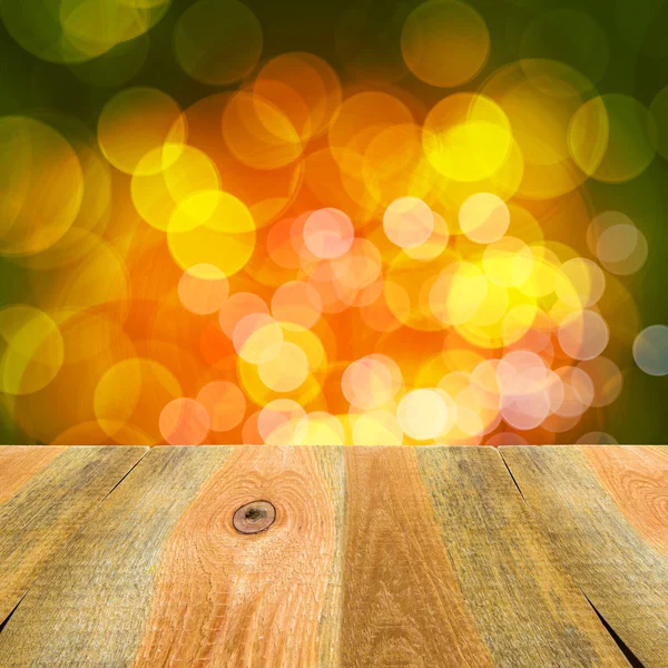 Groen oranje geel bokeh achtergrond houten tafel — Stockfoto