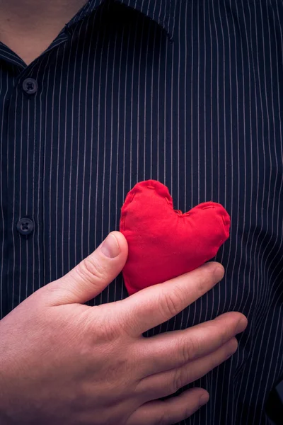Человек с красным сердцем крупным планом — стоковое фото