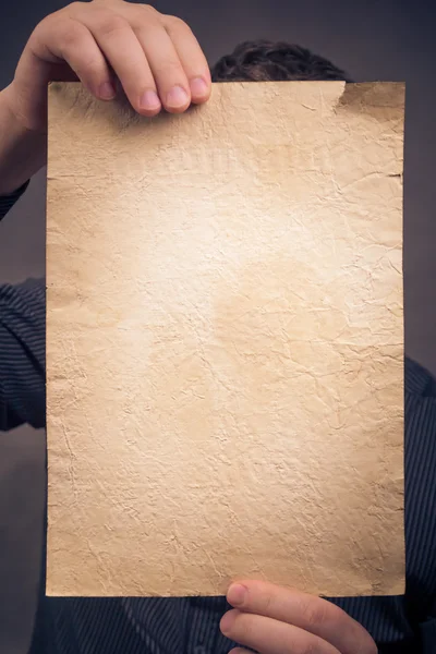Старий аркуш паперу рук вертикально — стокове фото