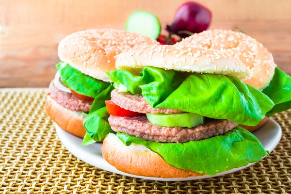 Två hemgjorda grillade hamburgare träbord — Stockfoto