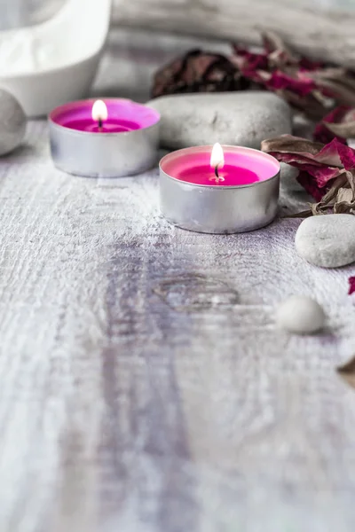 Piedras velas pétalos rosa fondo de madera — Foto de Stock