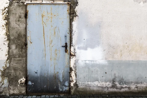 Parede de tijolo arruinada porta de aço fechada — Fotografia de Stock