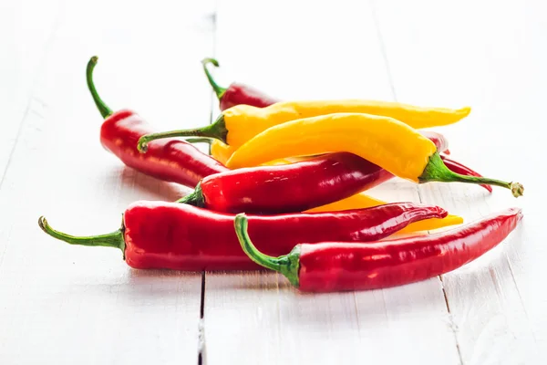 Rote gelbe Chilischoten hölzernen Hintergrund — Stockfoto