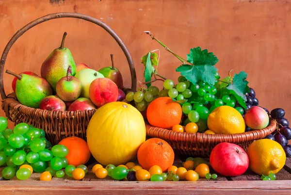 Mesa de madera llena de cestas de fruta fresca — Foto de Stock