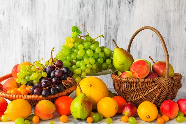 Mesa de madera llena de cestas de fruta fresca — Foto de Stock