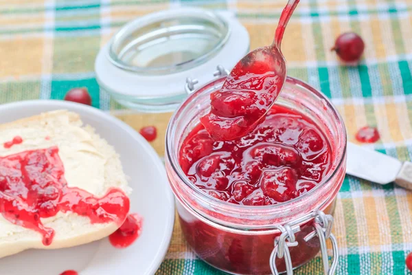 Scooping kruisbes jam pot lepel — Stockfoto