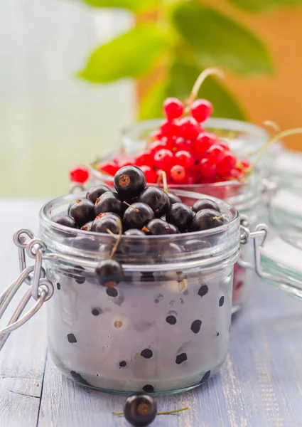 Colorful currant fruit jars wooden table — Stock Photo, Image