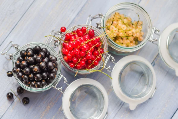 Colorful currant fruit jars wooden table — Stock Photo, Image