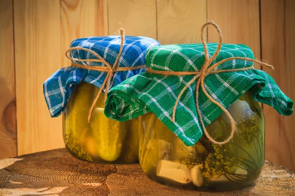 Pickled cucumbers jars wooden table — Stock Photo, Image