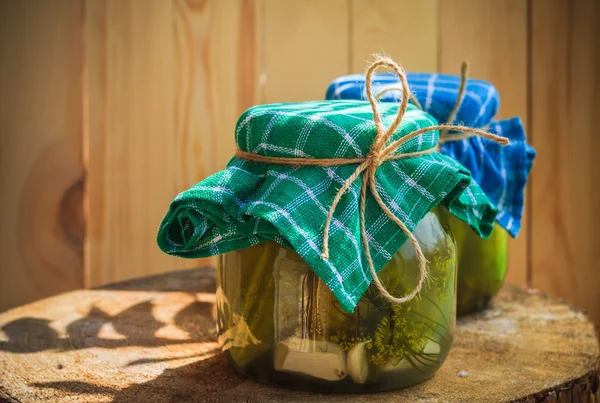 Pickled cucumbers jars wooden table — Stock Photo, Image