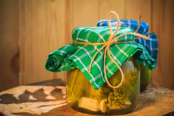 Mesa de madera de tarros de pepinos en vinagre —  Fotos de Stock