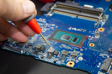 Bilgisayar tamir servisi. Mühendis ana bilgisayarı tamir ediyor. Donanım geliştiricisi elektronik bileşenleri ölçer. 