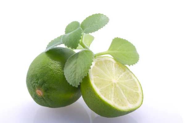Taze, doğal, yeşil limon, ikiye bölünmüş, beyaz arka planda taze nane..