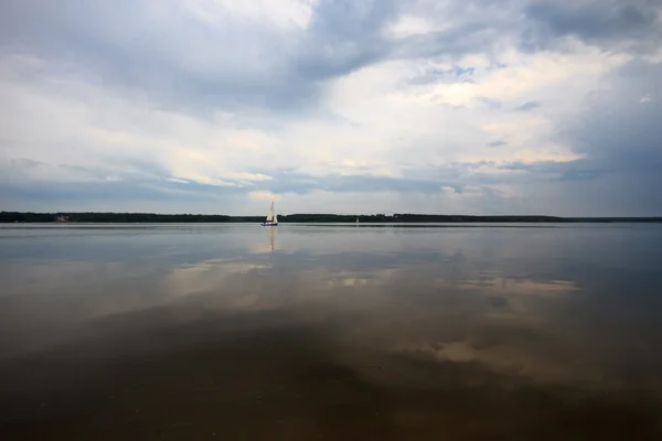 Голубое озеро с облачным небом — стоковое фото