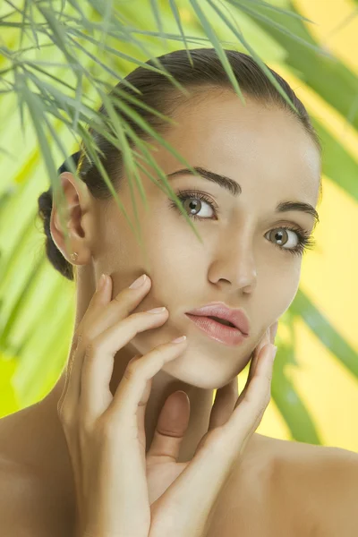 Portrait of young beautiful woman on green leafs back — Stock Photo, Image