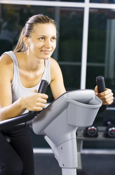 Portrait of young woman getting busy in gym — Stock Photo, Image