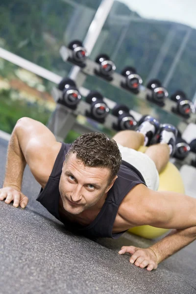 Portrait of young man getting busy in gym — Stock Photo, Image