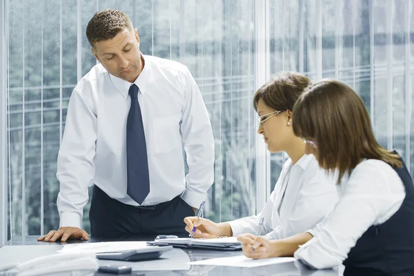 Portrait of young business getting busy in office environment — Stock Photo, Image