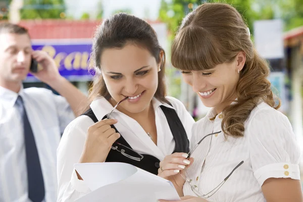 Portrait of young pretty women having conversation in office environment Stock Image