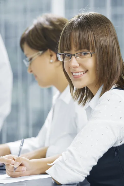 Portrait of young business getting busy in office environment — Stock Photo, Image