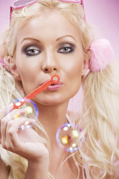 Portrait de jeune femme agréable avec des bulles de savon sur le dos rose — Photo