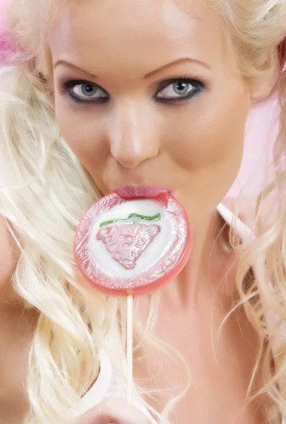 Porträtt av ung trevlig kvinna med lollypop på rosa baksida — Stockfoto