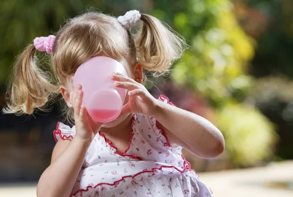 Porträtt av lilla flickan drink i sommaren miljö — Stockfoto