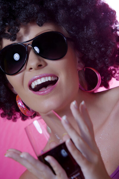 Portrait of young nice woman with glass of wine on pink back