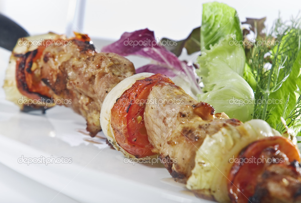 Close up view of nice delicious shish kebab on white back