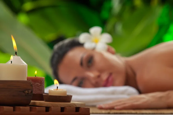 Retrato de una joven hermosa mujer en un ambiente de spa. Enfocado en velas . —  Fotos de Stock