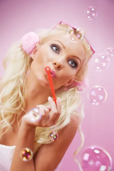 Ritratto di giovane bella donna con bolle di sapone sul retro rosa — Foto Stock