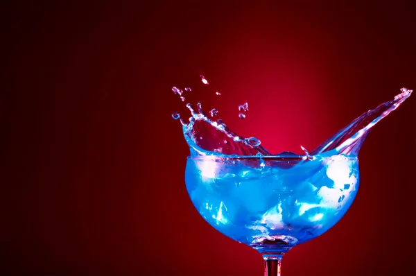 View of cocktail glass with blue Curacao splashing over — Stock Photo, Image