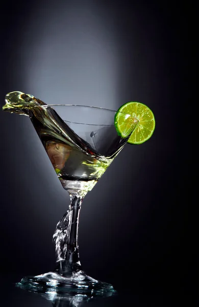 View of martini glass with piece of lime on black sheet — Stock Photo, Image