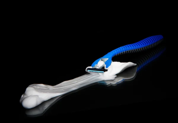 View of some shaving razor and foam on black sheet — Stock Photo, Image