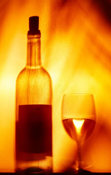 View of wineglasses and bottle silhouette on fire color back — Stock Photo, Image