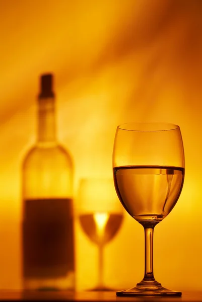 View of wineglasses and bottle silhouette on fire color back — Stock Photo, Image