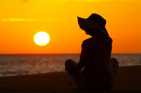 Silhouette d'une femme sur la plage au coucher du soleil — Photo