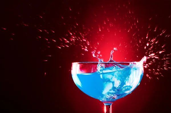 View of cocktail glass with blue Curacao splashing over — Stock Photo, Image