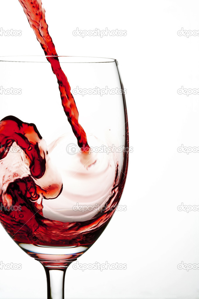 Close up view of wineglass getting filled with red wine