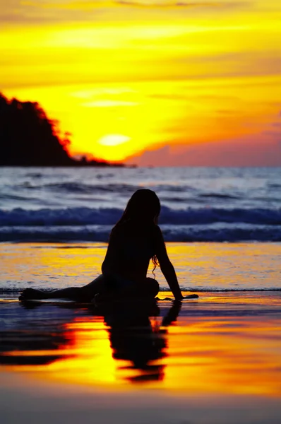 夕暮れ時の海辺の女性のシルエット — ストック写真